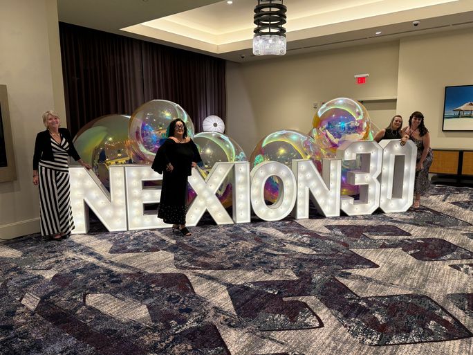 Advisors with the Nexion 30 sign outside the 30th anniversary gala.