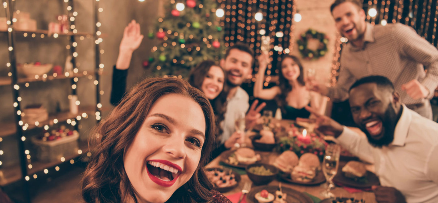 Image: A group of friends celebrating during a holiday gathering (Photo Credit: Adobe Stock/deagreez)