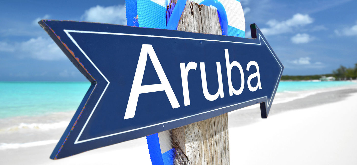 Image: Aruba sign on the beach. (photo via Pincasso / iStock / Getty Images Plus)