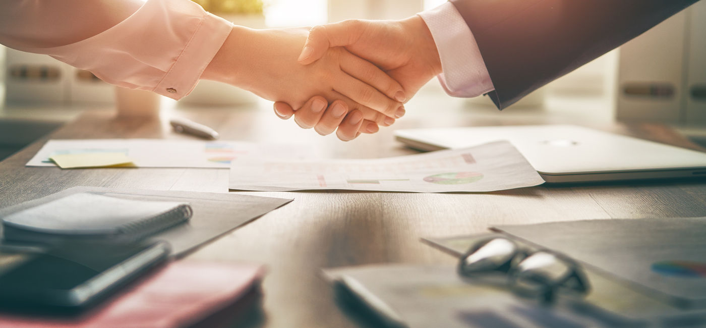 Image: Business handshake in an office. (Photo Credit: Konstantin Yuganov/Adobe)