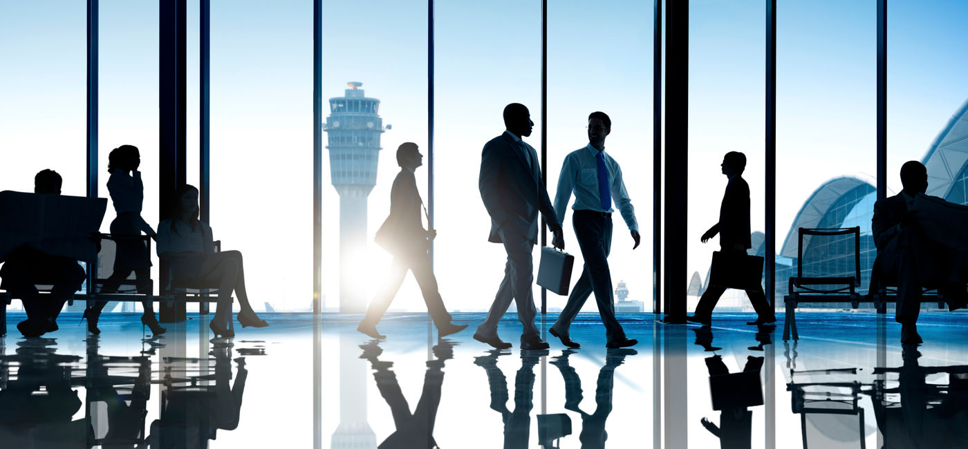 Image: Corporate or business travelers walking through the airport. (Photo Credit: Adobe Stock/Rawpixel.com)