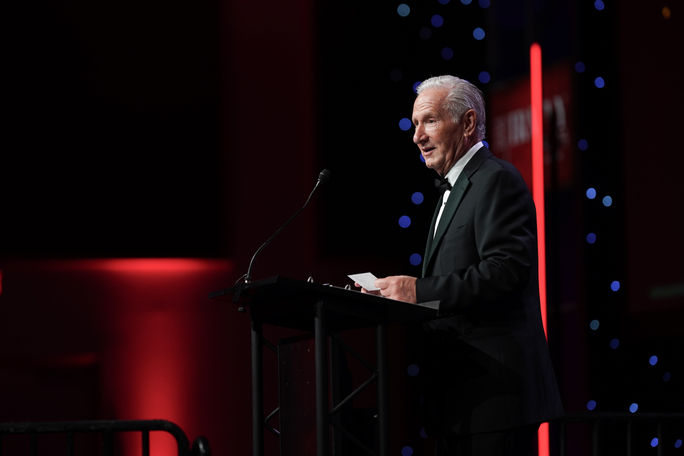 Michael Batt speaks on stage at the 2025 Travvy Awards