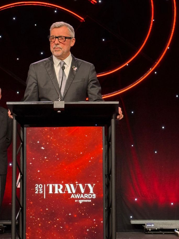 Michael Bayley accepts Travel Executive of the Year award at 2025 Travvy ceremony.